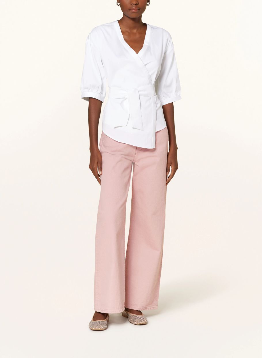 Model mit der Wickelbluse und rosa Hose