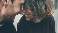 Porträt eines verliebten Paares, das man nicht erkennt. Sie sitzen Stirn an Stirn zueinander gewandt und lächeln sich an. - Foto: teksomolika/iStock