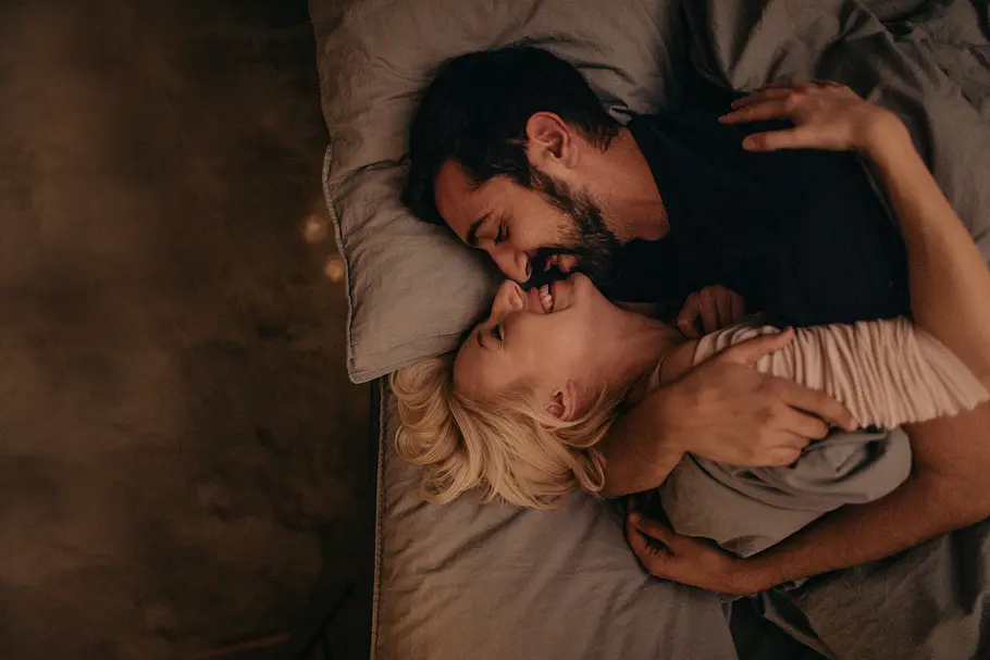 7 Fragen, die du dir stellen solltest, wenn du denkst die große Liebe gefunden zu haben Junges, heterosexuelles Paar, das zusammen zuhause im Bett kuschelt.