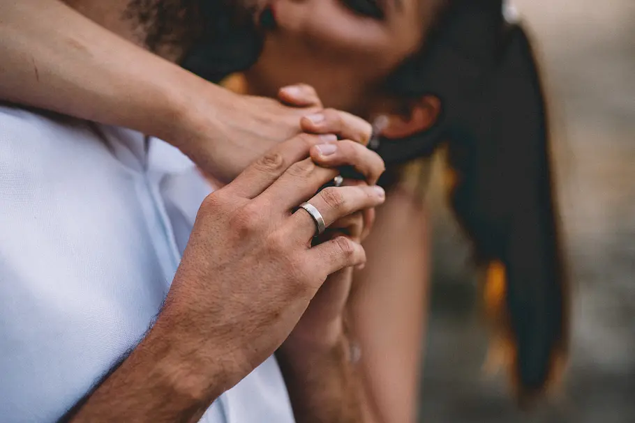 7 Momente, in denen Männer absolut unwiderstehlich sind Nahaufnahme eines unerkennbaren Pärchens, das Händchen hält und sich küsst.