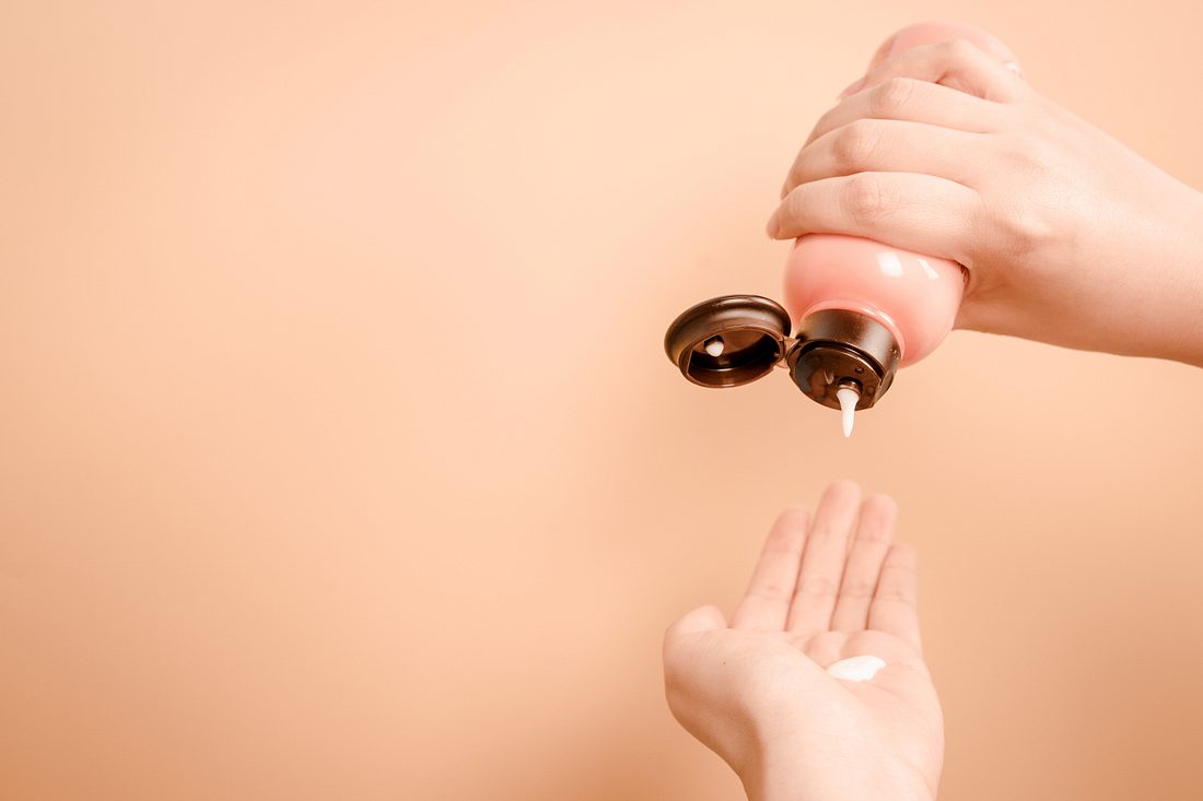 AHA-Peeling tropft auf eine Frauenhand AHA-Peeling tropft auf eine Frauenhand