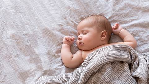 Baby schläft zugedeckt auf einer Matratze (Themenbild) - Foto: Amax Photo/iStock