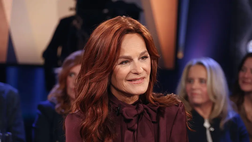 Andrea Berg sitzt in einem Sessel, blickt zur Seite und lächelt leicht. - Foto: IMAGO / Stephan Wallocha
