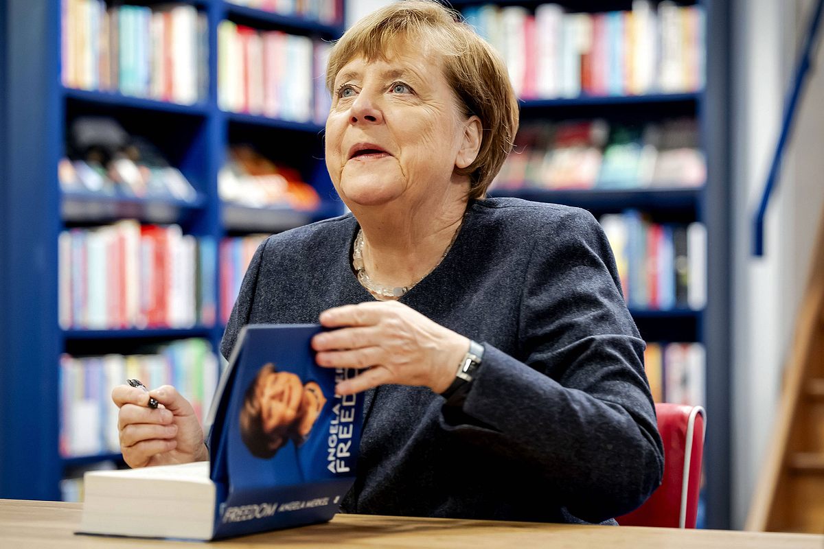 Angela Merkel signiert ihr Buch Freiheit in einer Buchhandlung.