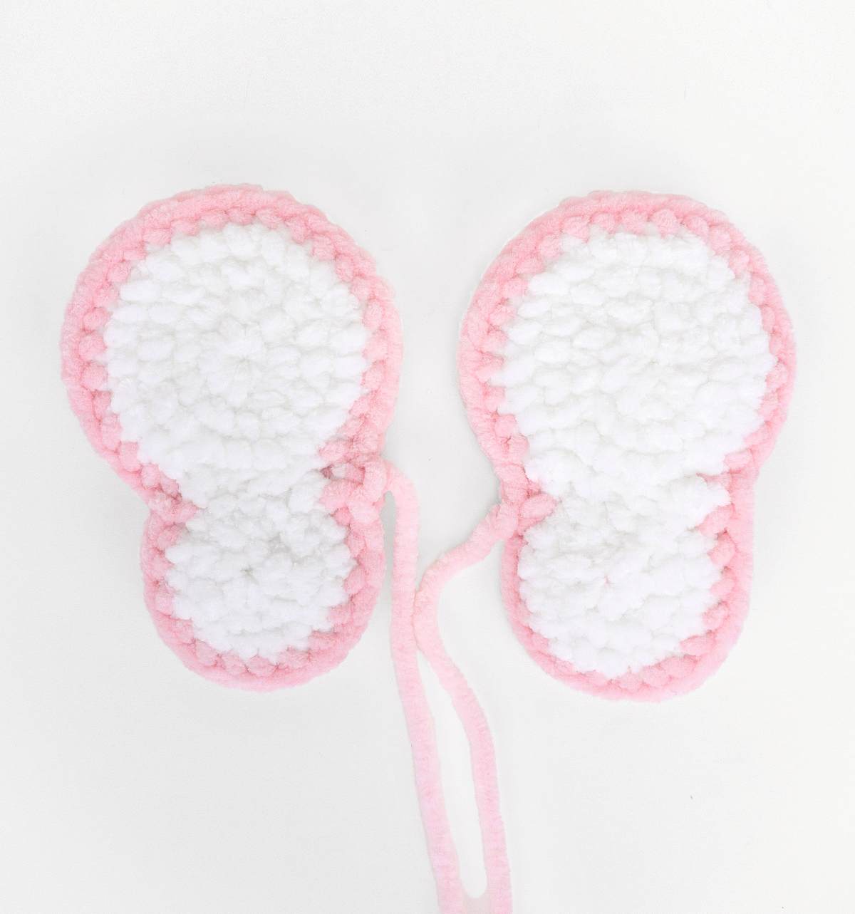 Anleitung Schmetterling häkeln Stepfoto 4 Die weiß-rosa Flügel eines gehäkelten Schmetterlings.