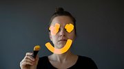 Traurige Frau malt Smiley auf einen Spiegel (Symbolbild) - Foto: Alpgiray Kelem/iStock