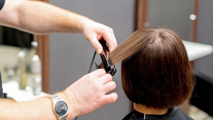 Mann schneidet Frau die Haare zu einem Bob (Themenbild) - Foto: okskukuruza/iStock