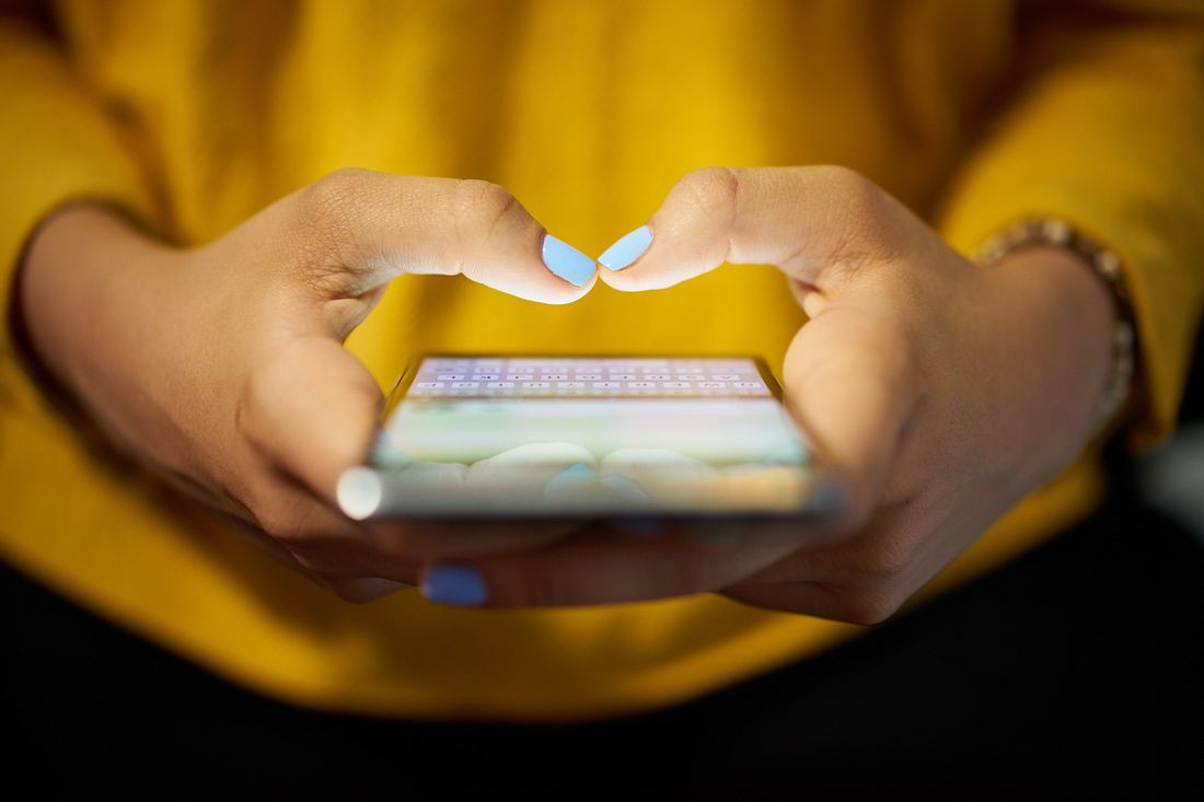 Anzeichen Liebesbetrüger im Internet Nahaufnahme: Frauenhände tippen am Smartphone etwas ein
