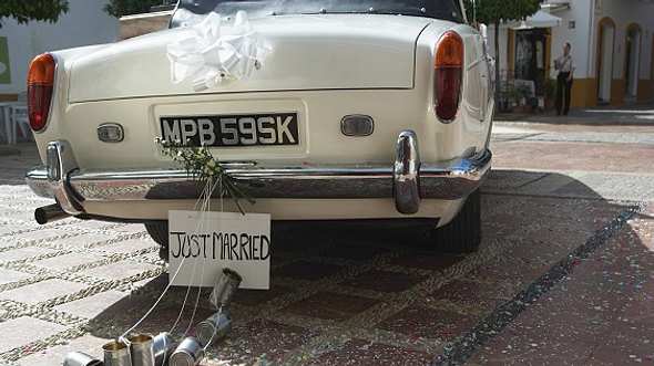 Autoschmuck für Hochzeiten an weißem Auto - Foto: iStock/Maria Teijeiro