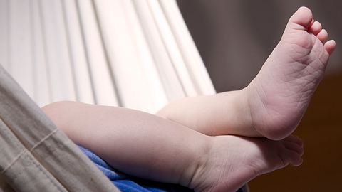 Ein Baby liegt in einer Baby Hängematte. - Foto: iStock/ Islandgirl