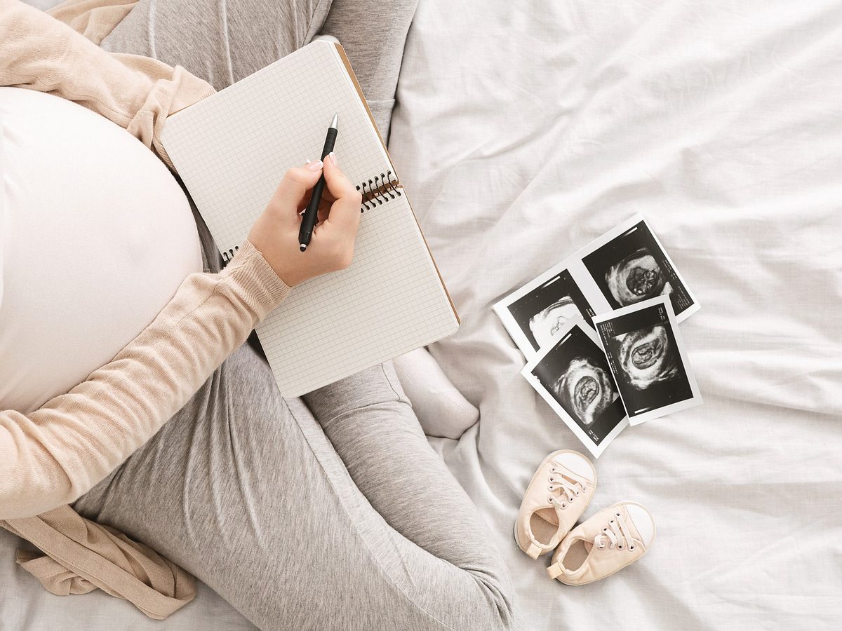 Schwangere Frau gestaltet Babybuch