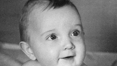 Schwarz-Weiss-Nahaufnahme eines Babys, das in die Kamera lächelt. - Foto: iStock/hooky13