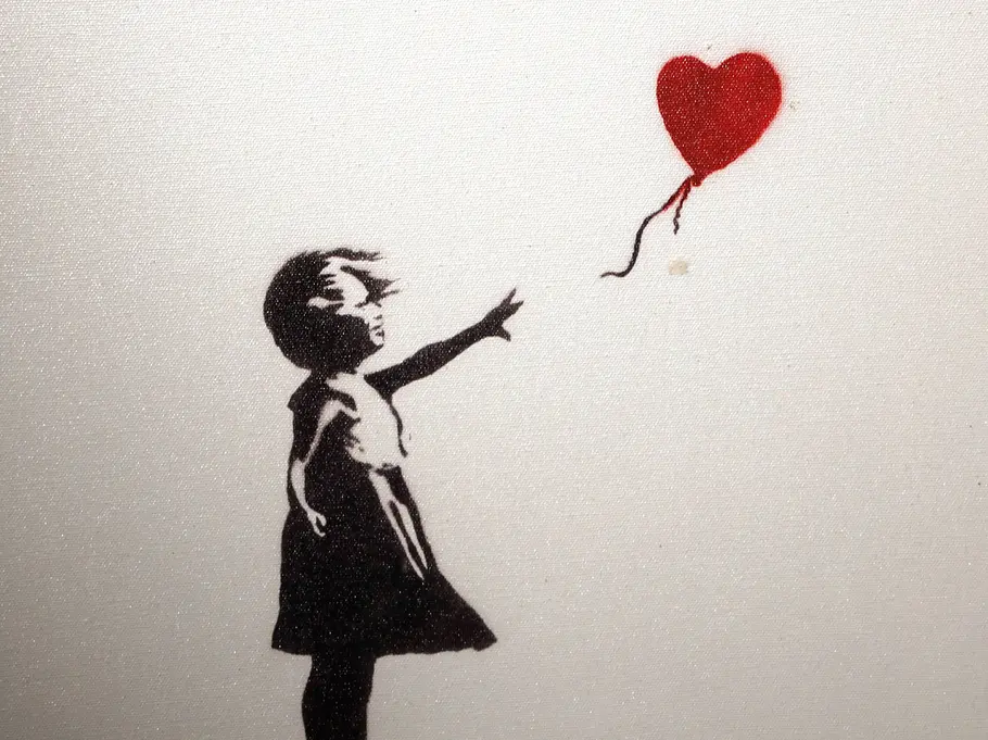 Banksy Banksy-Motiv „Girl with Balloon“: Schwarze Schablone eines Mädchens, das nach einem roten herzförmigen Ballon greift, auf hellem Hintergrund.
