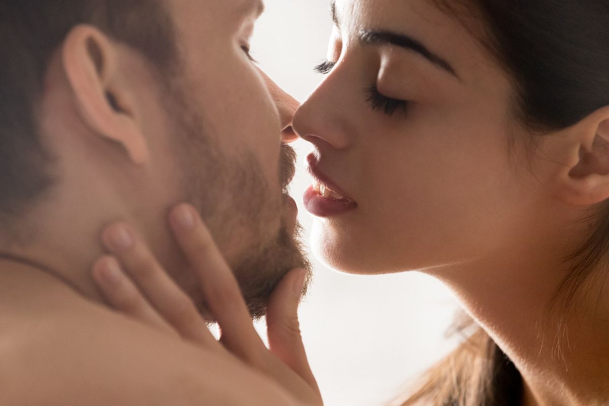 Frau und Mann kommen sich mit den Lippen nah.