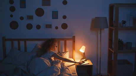 Frau schaltet das Nachtlicht zum Einschlafen aus - Foto: iStock/ SeventyFour