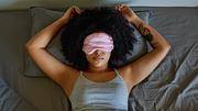 Frau liegt mit Schlafmaske im Bett - Foto: istock/LaylaBird