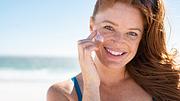 Frau trägt sich Sonnencreme im Gesicht auf - Foto: iStock / Ridofranz