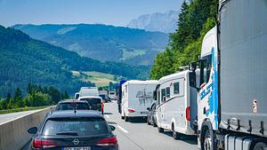 Stockender Urlaubsverkehr auf einer Autobahn bei den Alpen auf der A10 Richtung Villach Slowenien Pfarrwerfen Land Salzburg Österreich. PKWs, Wohnmobile und LKWs. - Foto: IMAGO / Steinsiek.ch (Themenbild)