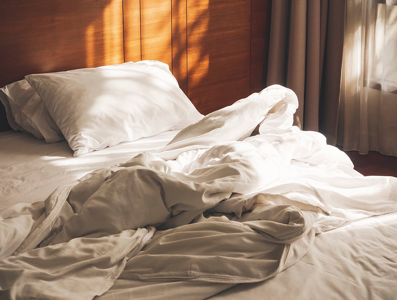 Ein Bett mit Bio-Bettwäsche bezogenem Kissen und Bettdecke.