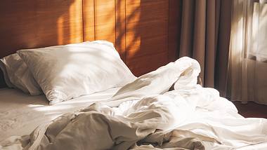 Ein Bett mit Bio-Bettwäsche bezogenem Kissen und Bettdecke. - Foto: iSock/VTT Studio