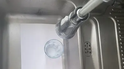 Ein Blatt Papier, darauf ein Glas Wasser im Küchen-Spülbecken  - Foto: Privat