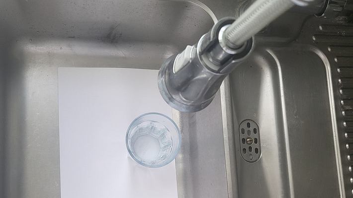 Ein Blatt Papier, darauf ein Glas Wasser im Küchen-Spülbecken  - Foto: Privat