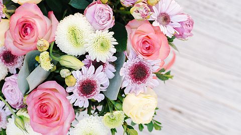 The composition of flowers in the box is photographed from above. The flower arrangement consists of roses, chrysanthemum and eustoma - Foto: Maryna Terletska/iStock