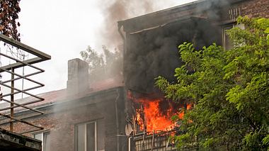 Feuer auf dem Balkon eines fünfstöckigen Gebäudes. Feuer und schwarze Rauchwolken. Rauch in der Wohnung. - Foto: Oksana Kuznetsova/iStock
