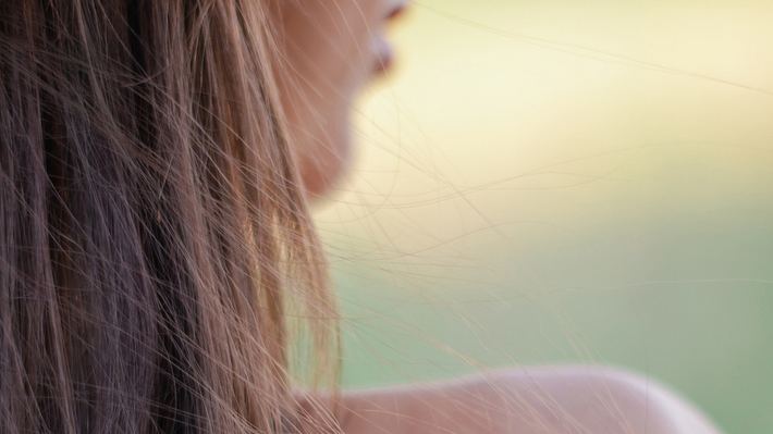 Junge Frau mit gebräunter Haut im Schatten (Themenbild) - Foto: Olga Skred/iStock