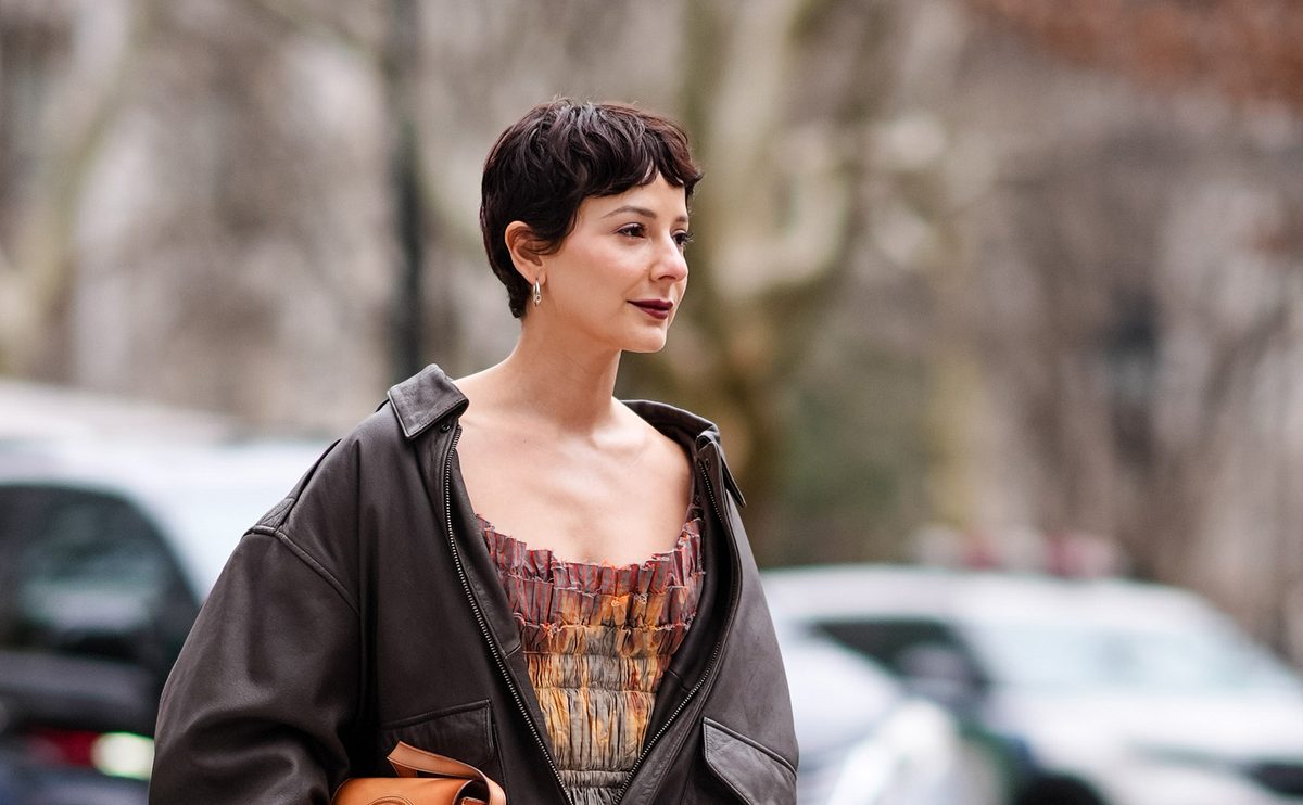 Elegant und feminin kommt der dunkelbraune Pixie Cut mit kurzen Curtain Bangs daher.