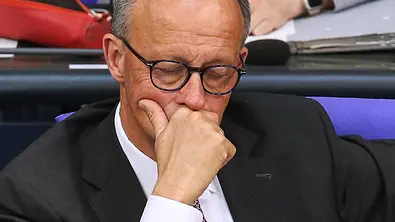 Ein traurig wirkender Bundeskanzler Friedrich Merz mit geschlossenen Augen und Hand vor dem Mund.  - Foto: IMAGO / dts Nachrichtenagentur