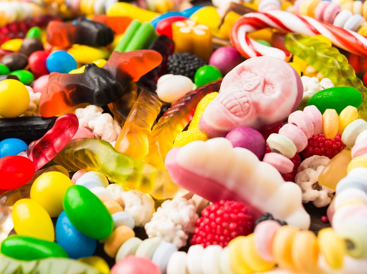 Viele bunte Süßigkeiten mit einem rosa Candy-Totenkopf (Themenbild)
