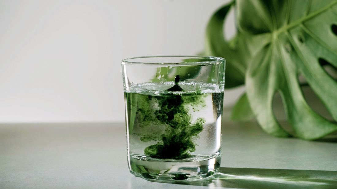 Chlorophyll Glas mit Wasser und Chlorophyll-Tropfen