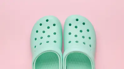 Crocs Alternative auf einem pinken Untergrund - Foto: iStock/KVLADIMIRV 