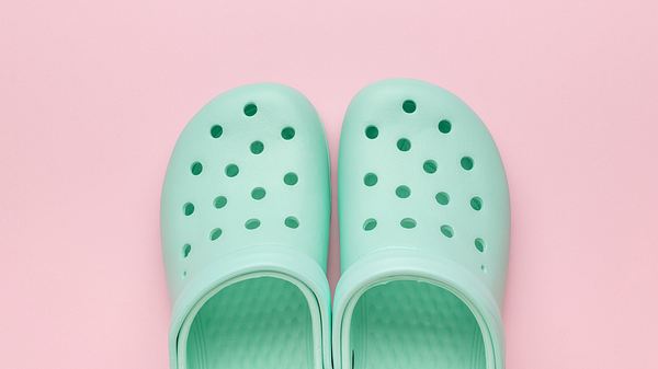 Crocs Alternative auf einem pinken Untergrund - Foto: iStock/KVLADIMIRV 