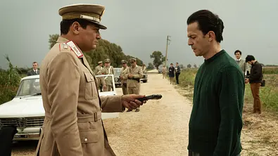 Ein Polizist und ein Mann im Vordergrund, im Hintergrund weitere Polizisten. - Foto: EMANUELA SCARPA/NETFLIX