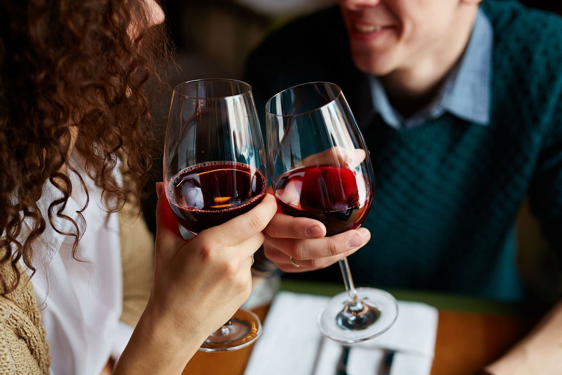 Verliebtes Paar beim Toasten mit Rotwein im Restaurant
