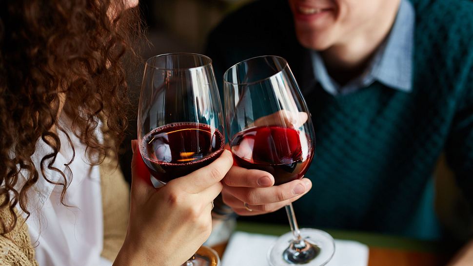 Verliebtes Paar beim Toasten mit Rotwein im Restaurant - Foto: shironosov / iStock