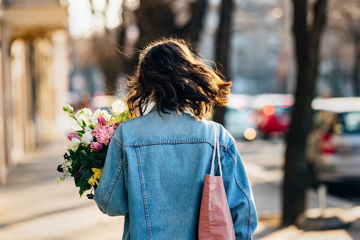 Eine Frau hält einen Blumenstrauß in der Hand (Themenbild)