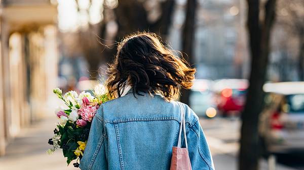 Eine Frau hält einen Blumenstrauß in der Hand (Themenbild) - Foto: miniseries/iStock