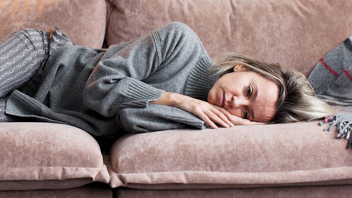 Frau liegt mit traurigem Gesichtsausdruck auf der Couch (Themenbild). - Foto: AdobeStock/Tatyana Gladskih