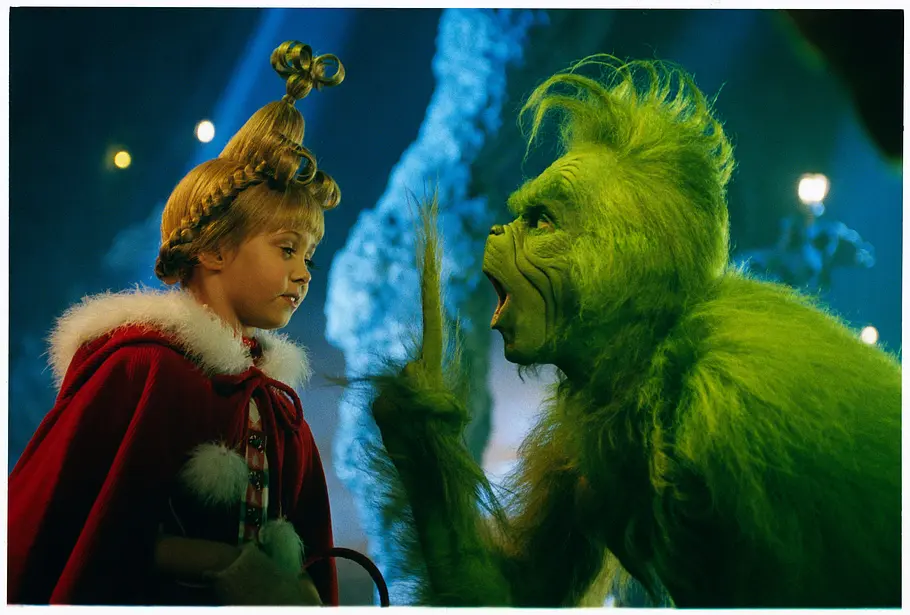 Der Grinch (2000) Der Grinch meckert Cindy Lou an. Sie hat eine ungewöhnlich geflochtene Friseur. Der Grinch ist grün und haarig.
