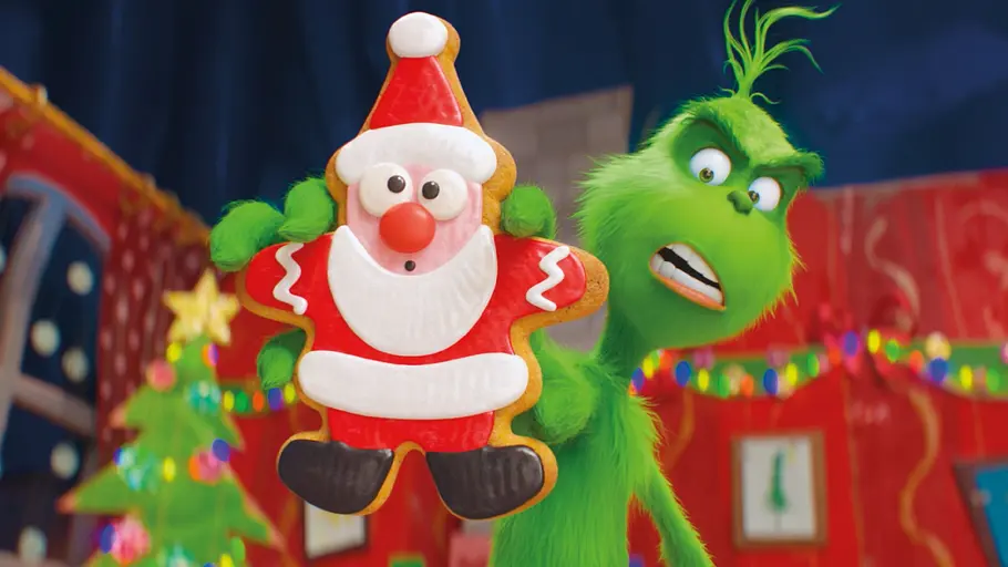 Der Grinch (2018) Der animierte Grinch hält ein Weihnachtsmann-Lebkuchen in die Kamera.