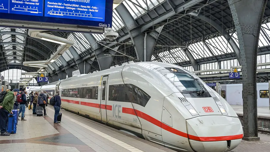 Deutsche Bahn: Hackerangriff legt Fahrplan-Systeme lahm ICE-Zug der Deutschen Bahn steht in einer Bahnhofshalle am Bahnsteig, während Reisende auf die Abfahrt warten