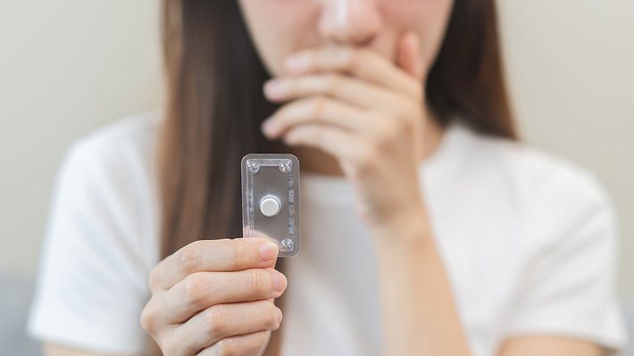 Frau hält Pille danach in der Hand. (Themenbild) - Foto: AdobeStock / KMPZZZ