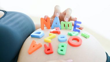 Schwangere Frau mit Spielbuchstaben auf dem Bauch - Foto: adrian825/iStock