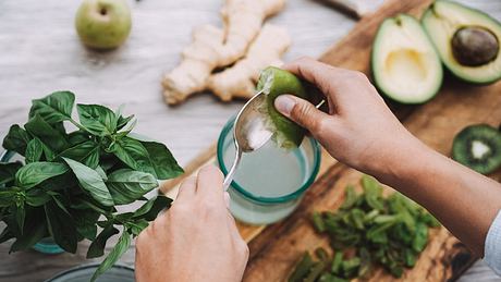 Frau bereitet Detox-Saft mit grünem Gemüse zu - Foto: Symbolbild: DisobeyArt/iStock