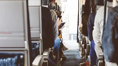 Ein Ganz im Flugzeug mit sitzenden Passagieren. - Foto: izusek/iStock