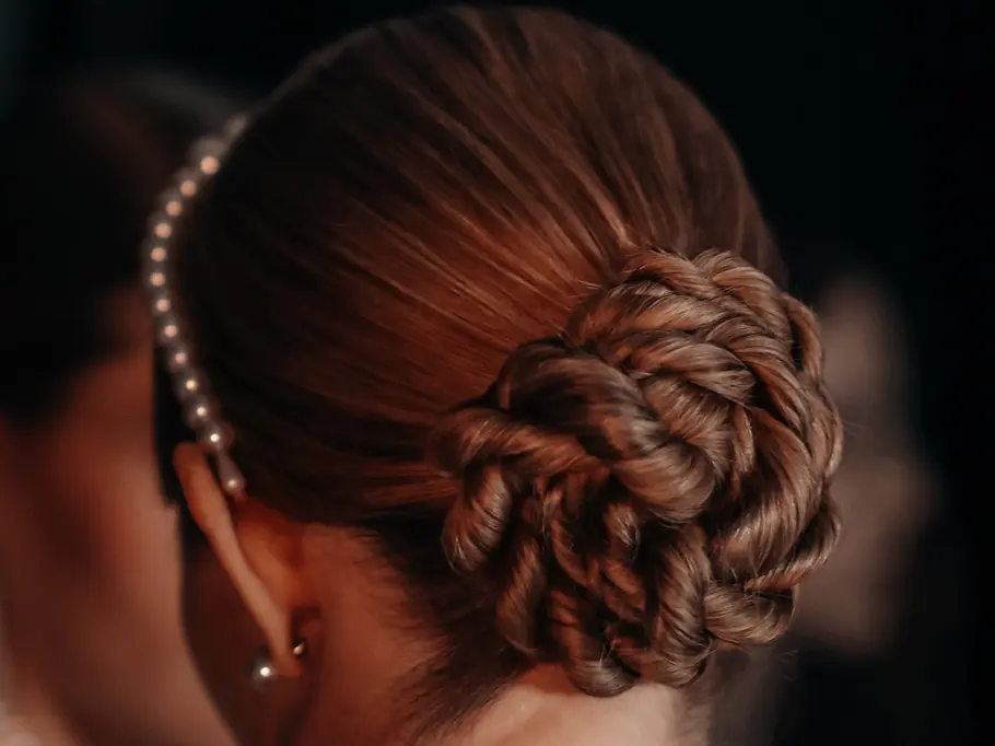 Frau von hinten mit braunen Haaren, Perlenhaarreif und einem Dutt 
