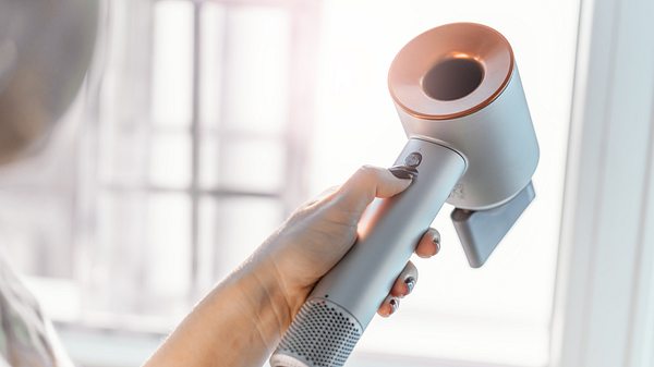 Frau hält eine Dyson Föhn Alternative - Foto: istock/nerudol